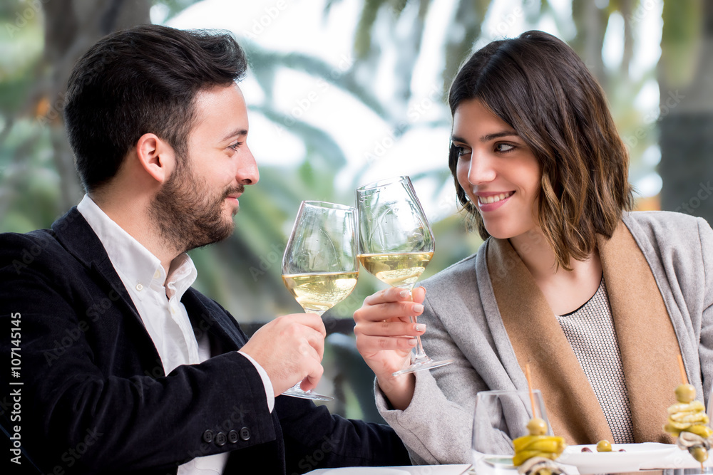 Elegant Couple making toast with white wine in restaurant. Elegant Couple making toast with white wine in restaurant.