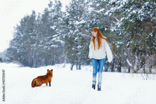 Beautiful girl with red fox on walk