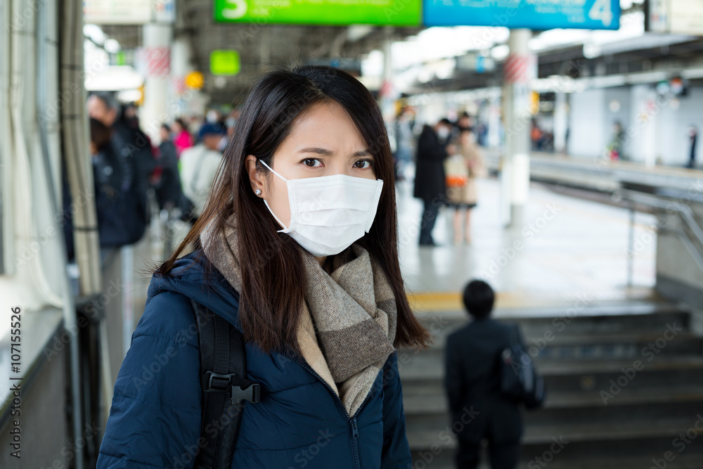 Woman wear face mask in train station Woman wear face mask in train station
