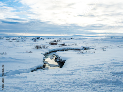 River in the middle of snow during summer in iceland