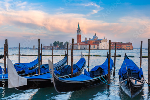 Gondolas moored by Saint Mark square with San Giorgio di Maggiore church in the background in the evening  Venice  Italia