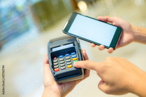 Customer using cellphone for pay on pos machine
