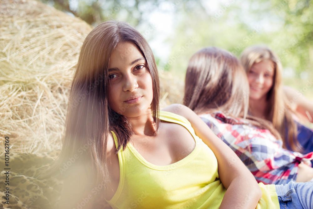 Three girl friends having fun on hay stack Three girl friends having fun on hay stack