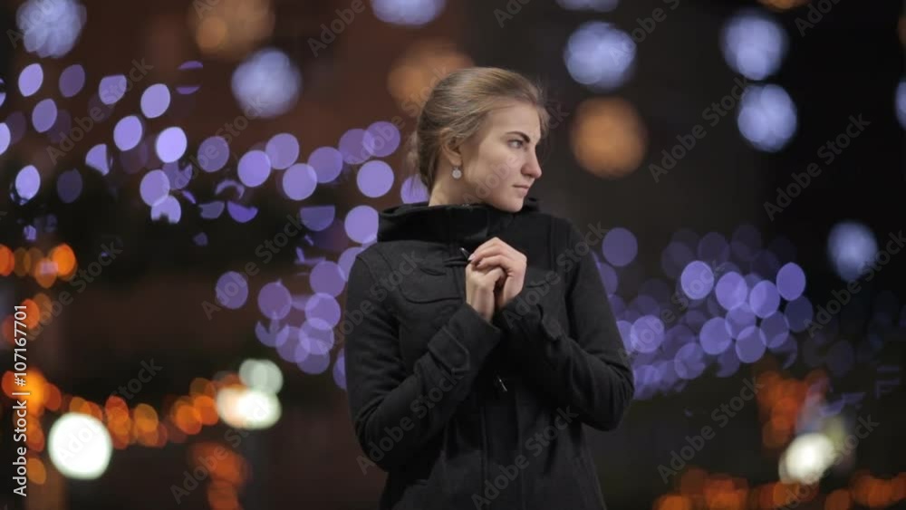beautiful girl on the background of Christmas lights warms his hands near the face beautiful girl on the background of Christmas lights warms his hands near the face