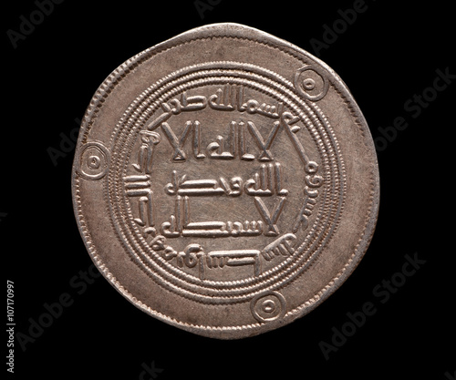 Arabic ancient silver coin isolated on black photo