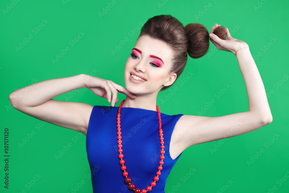 Happy beautiful girl in a blue dress in the style of pin-up isolated on a green background