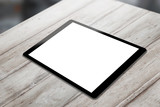 Black tablet on wooden table with isolated white screen for mockup. Horizontal position isometric view.