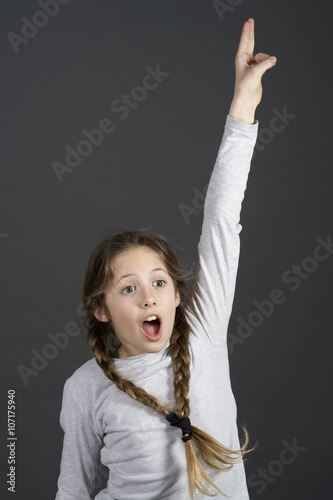cute teenager girl knows the answer with hands up photo