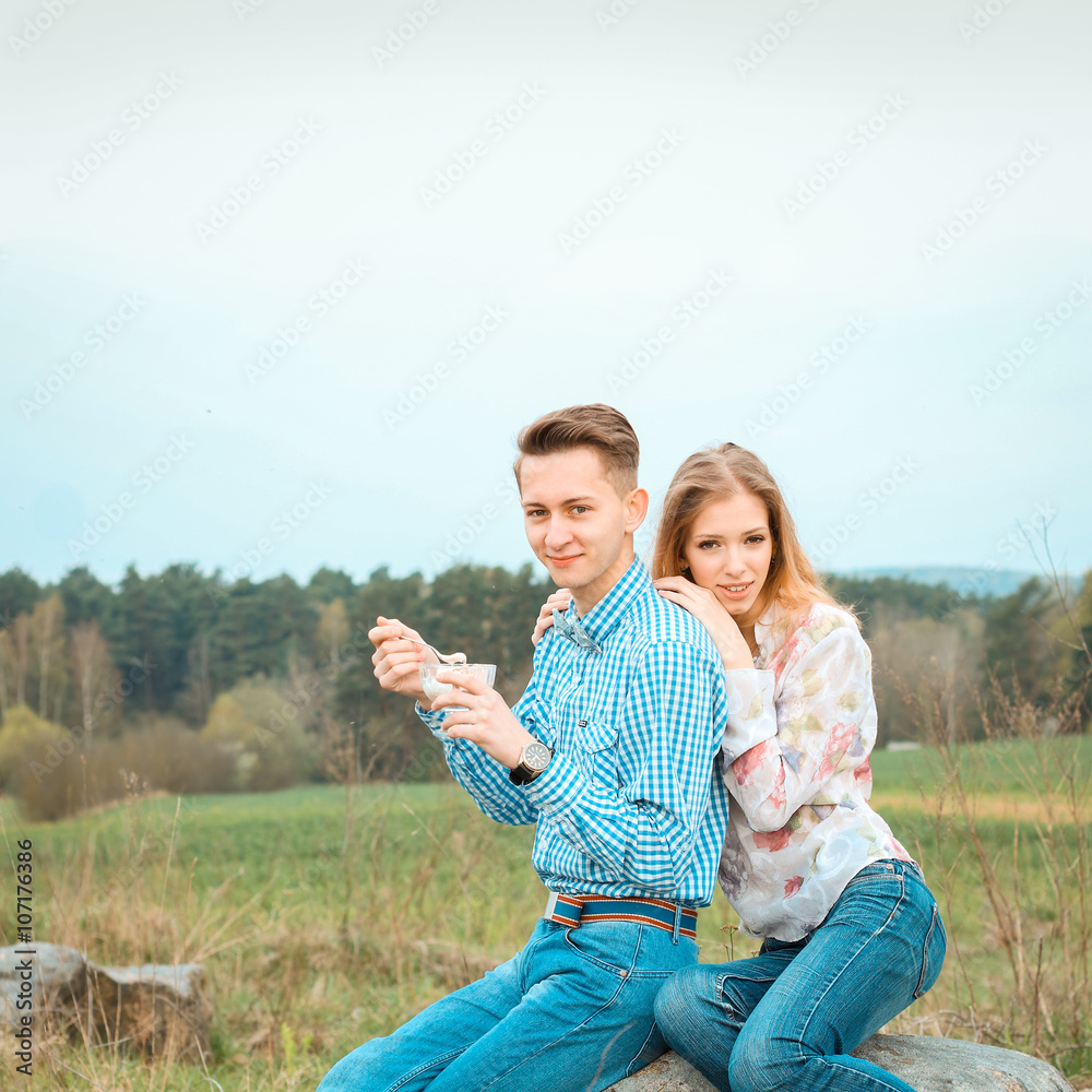 Pretty nice young couple eating ice cream outdoors. Young couple in nature Pretty nice young couple eating ice cream outdoors. Young couple in nature