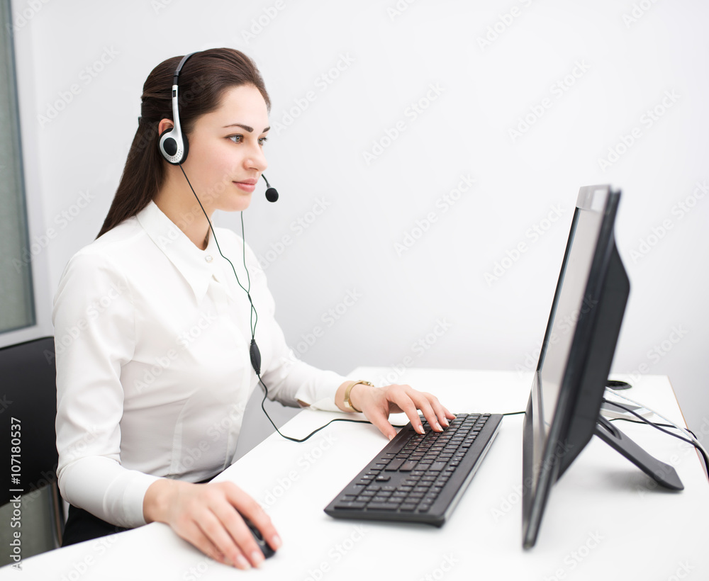 young business woman working at a computer with headphones young business woman working at a computer with headphones