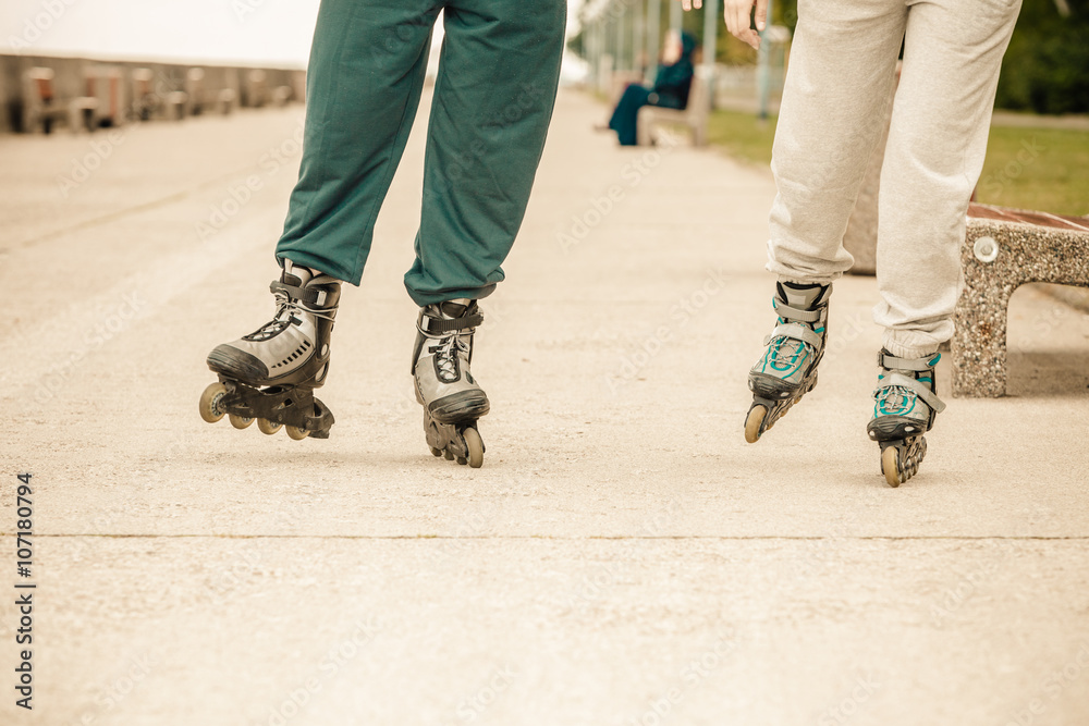 Friends outdoors have fun rollerblading together. Friends outdoors have fun rollerblading together.