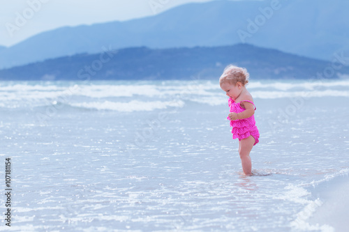 Little cute happy girl bathes in sea, Italy, outdoor