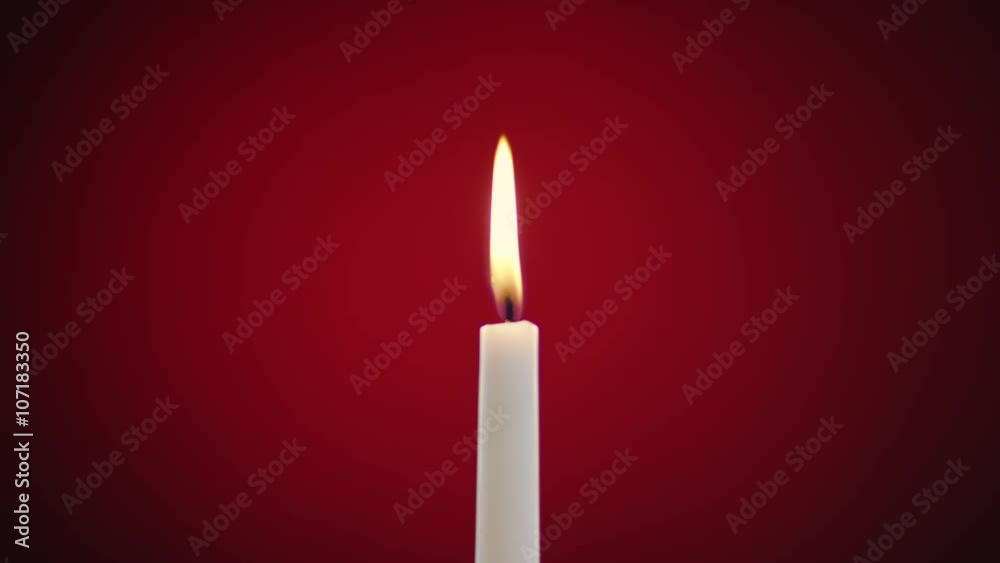 burning candle on a red background burning candle on a red background