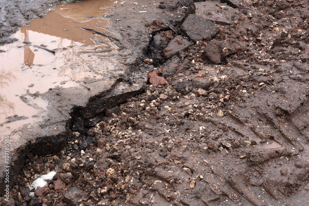broken road. dirt and water on the pavement. broken road. dirt and water on the pavement.