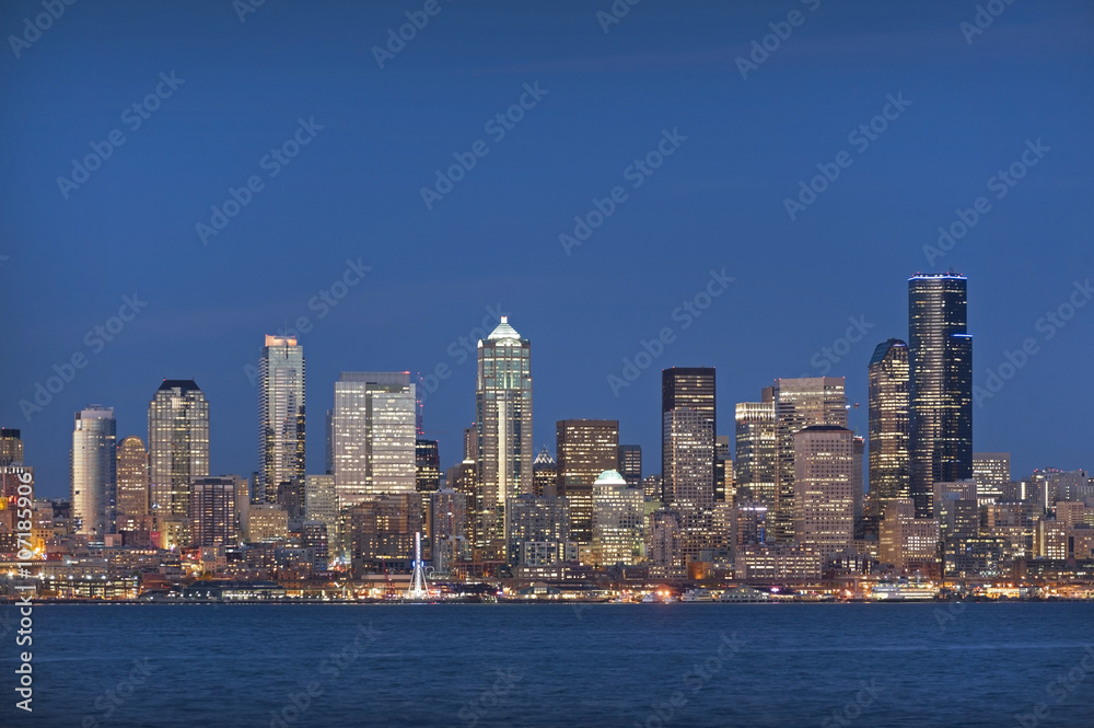 Fototapeta premium Seattle, Washington at Night. Lights from modern office buildings add sparkle to a glorious sunset over the 