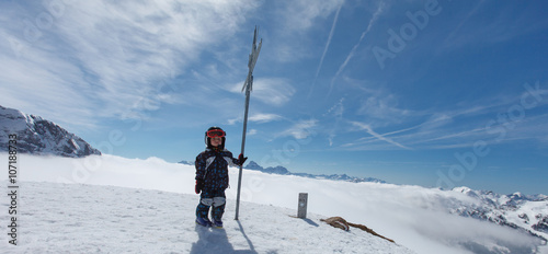 Cute little skier and alpine panorama.