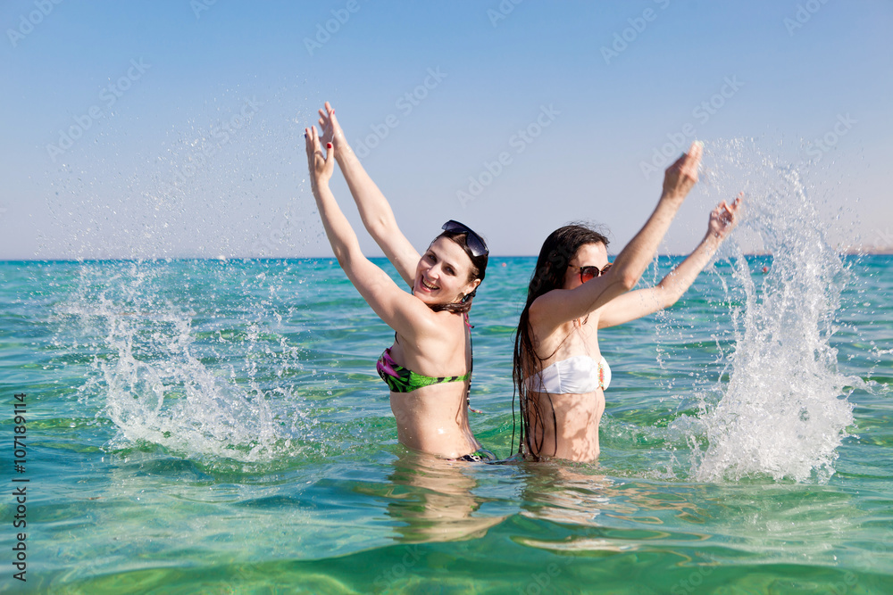 Young woman sprinkles water in the sea Young woman sprinkles water in the sea