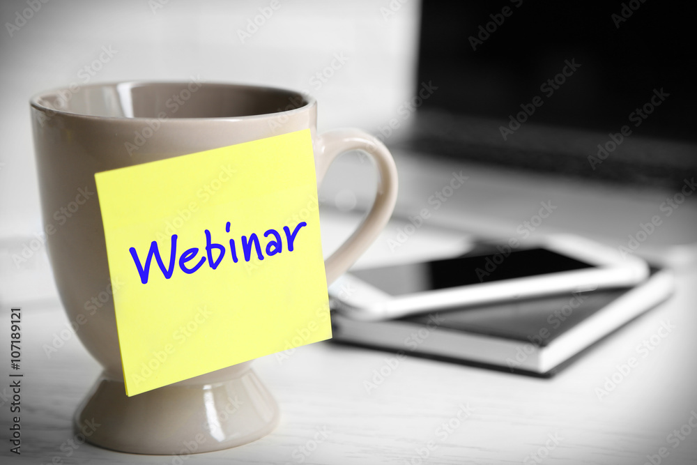 A cup with sticky note on the office table, close up. Webinar concept A cup with sticky note on the office table, close up. Webinar concept