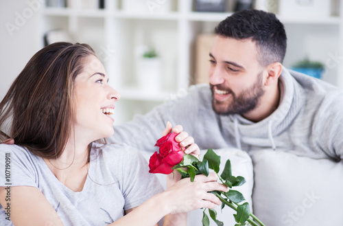 Young man giving a red rose to his girlfriend