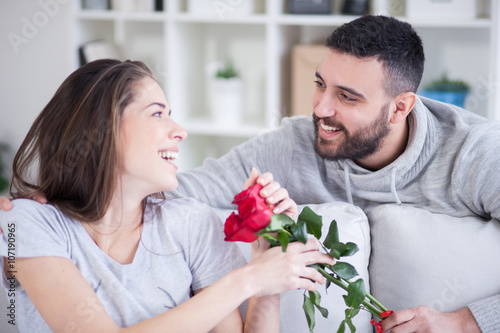 Young man giving a red rose to his girlfriend