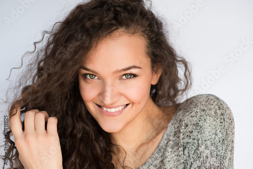 Cute smiling young woman with curly hair