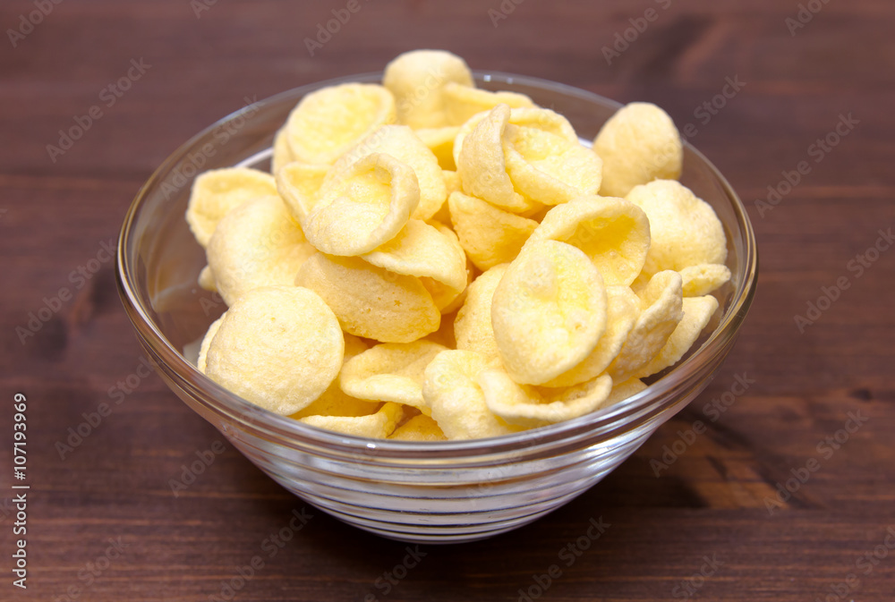 Potato snacks on bowl on wooden table Potato snacks on bowl on wooden table