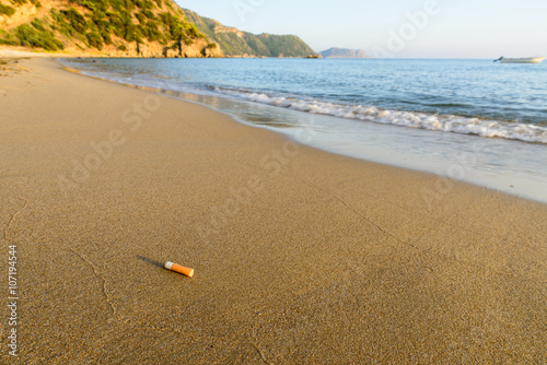 Fototapeta Naklejka Na Ścianę i Meble -  Cigarette butt sandy beach