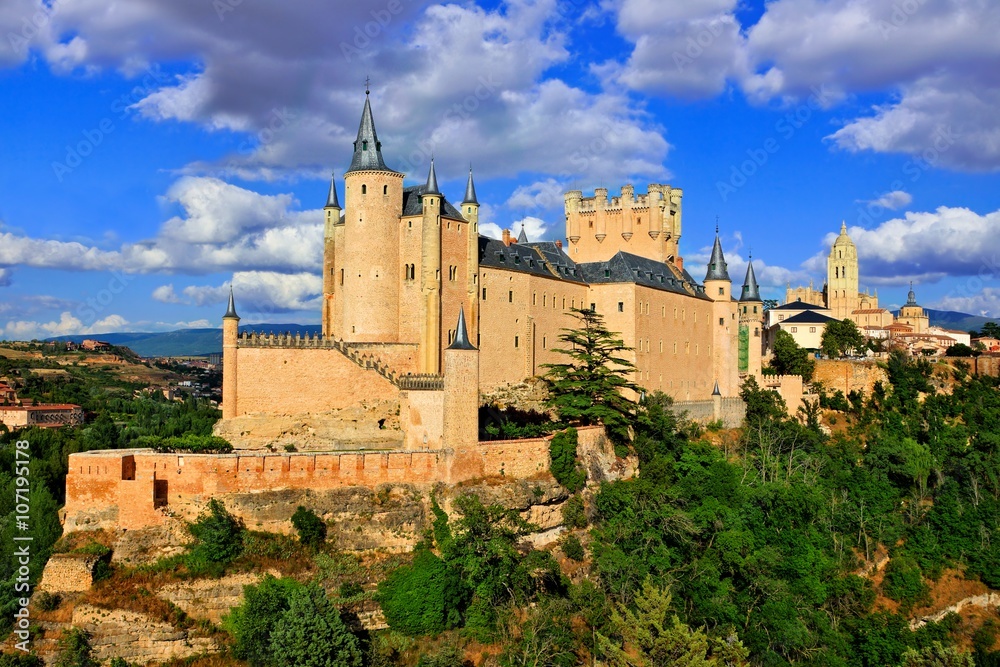 Beautiful Segovia Castle, Spain perched on a rocky hill with the old town behind