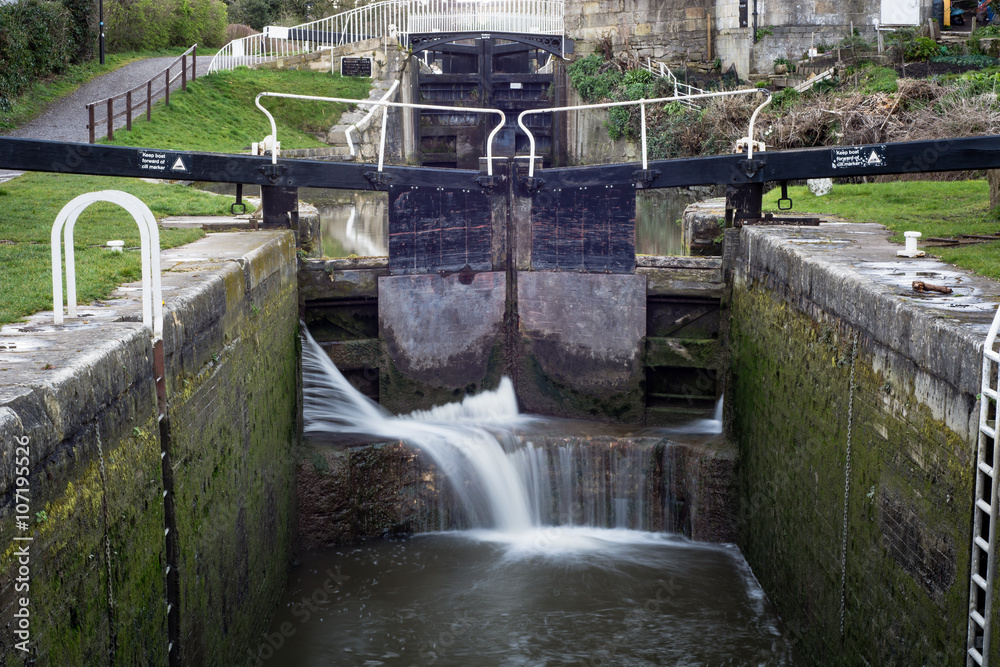 Widcombe locks on Kennet and Avon Canal. Lock with water escaping at ...