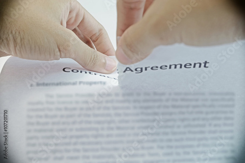 Foto The contract was torn by both hand in sepia mode(Using font for commercial able)