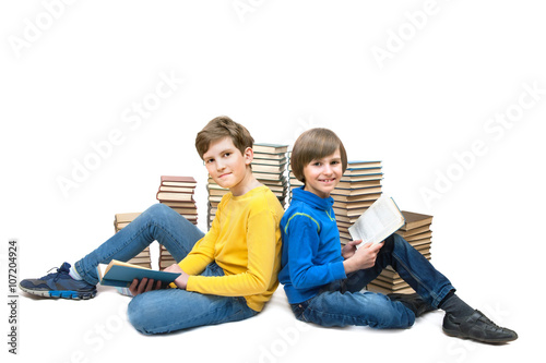 Obraz w ramie two boys are sitting on the floor at the stacks of books and reading