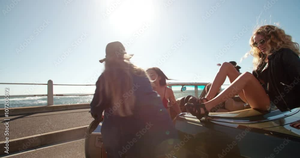 Group of hipster friends celebrating their vacations at the beach