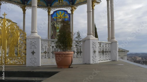 Wallpaper Mural Man is Walking Downhill Out of Summer Altar Alcove Golden Gate Columns Evergreen Trees in Pots Holy Dormition Pochaiv Lavra Orthodox Monastery in Pochaiv Torontodigital.ca