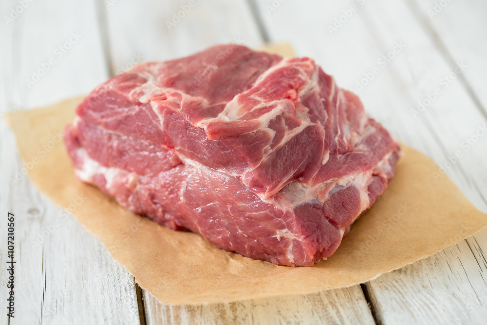 raw pork neck meat on wooden table