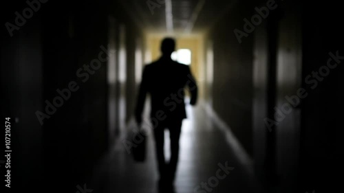 The silhouette of a man goes through the dark corridor to a bright future. The Ghost of a businessman .The path to success.