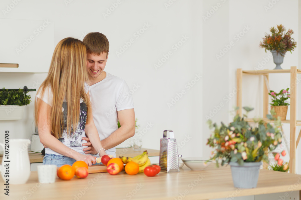 Young couple cooking - man and woman in their kitchen