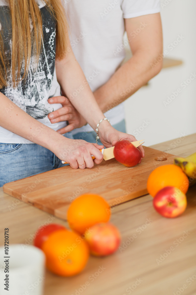 Young couple cooking - man and woman in their kitchen Young couple cooking - man and woman in their kitchen