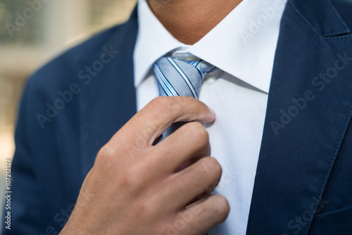 Fotografie Businessman adjusting his tie