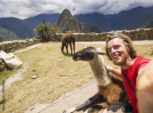 self-portrait of smiling man near lama, machu-picchu, peru photo