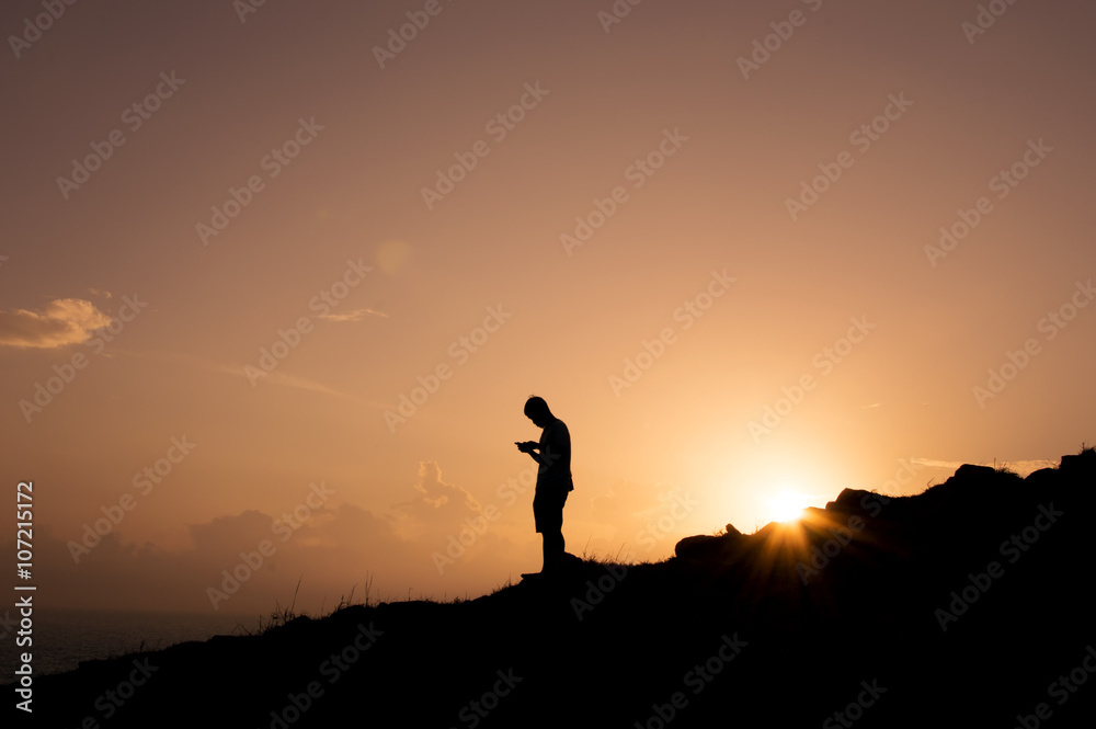 Phubbing, Silhouette man taking smart phone on the hill 