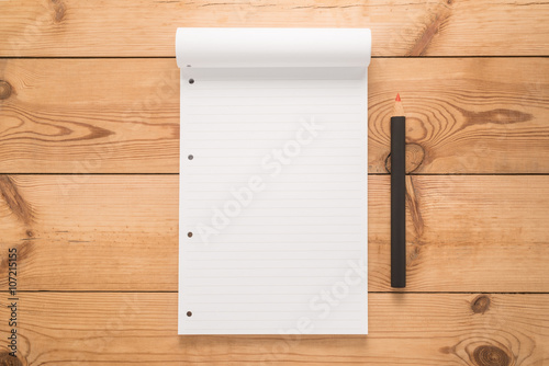 Notepad with pencil on a wooden desk 