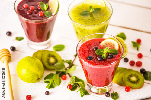fresh berry smoothies. fruit cocktail with kiwi, currant, cranberry, lime, honey and mint. healthy eating. diet and detox concept.
