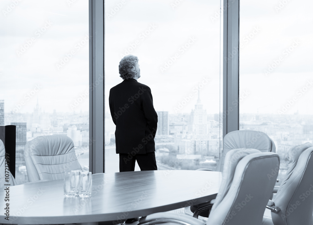 Middle age businessman looking out the window Middle age businessman looking out the window