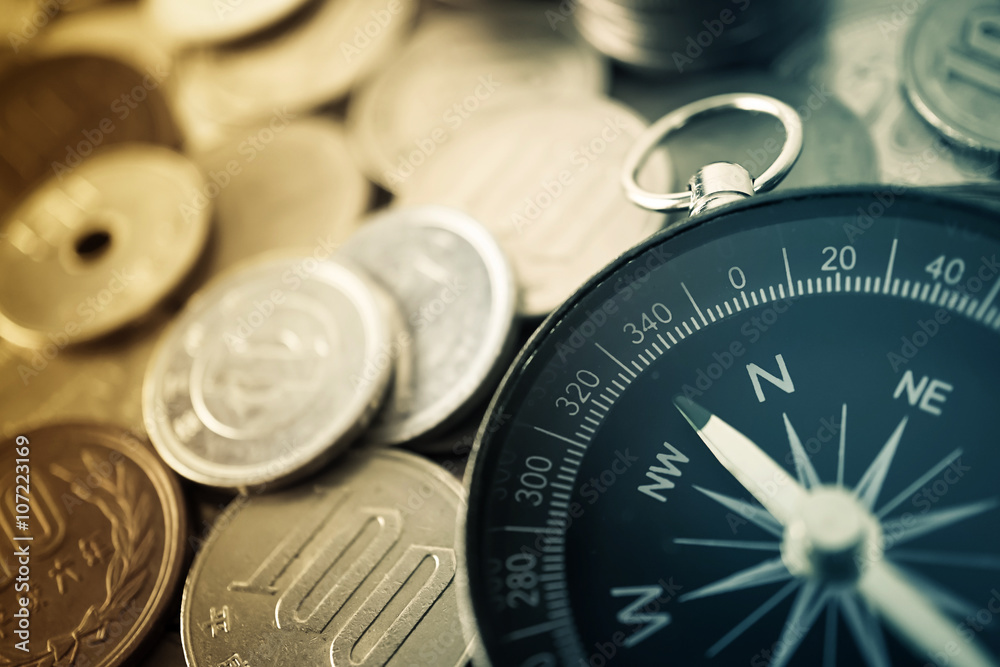 Compass on Coins for financial direction concept


