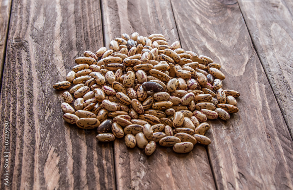 Light crude beans on a wooden table Light crude beans on a wooden table