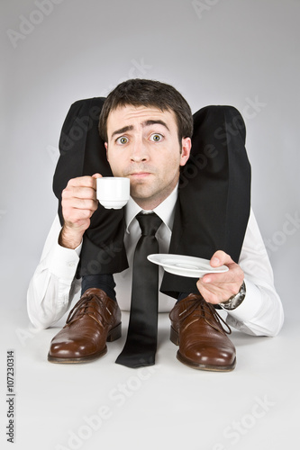 flexible businessman with doubtful face isolated on white drinking coffee photo