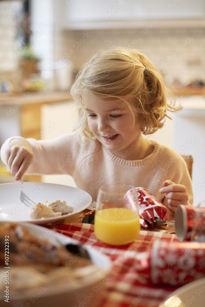 A young girl sitting at a table having a meal. A young girl sitting at a table having a meal.