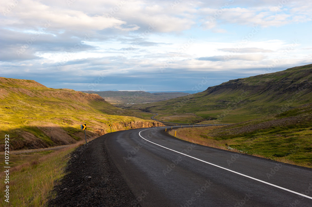 Landscape with mountains and meandering road at sunset, Iceland