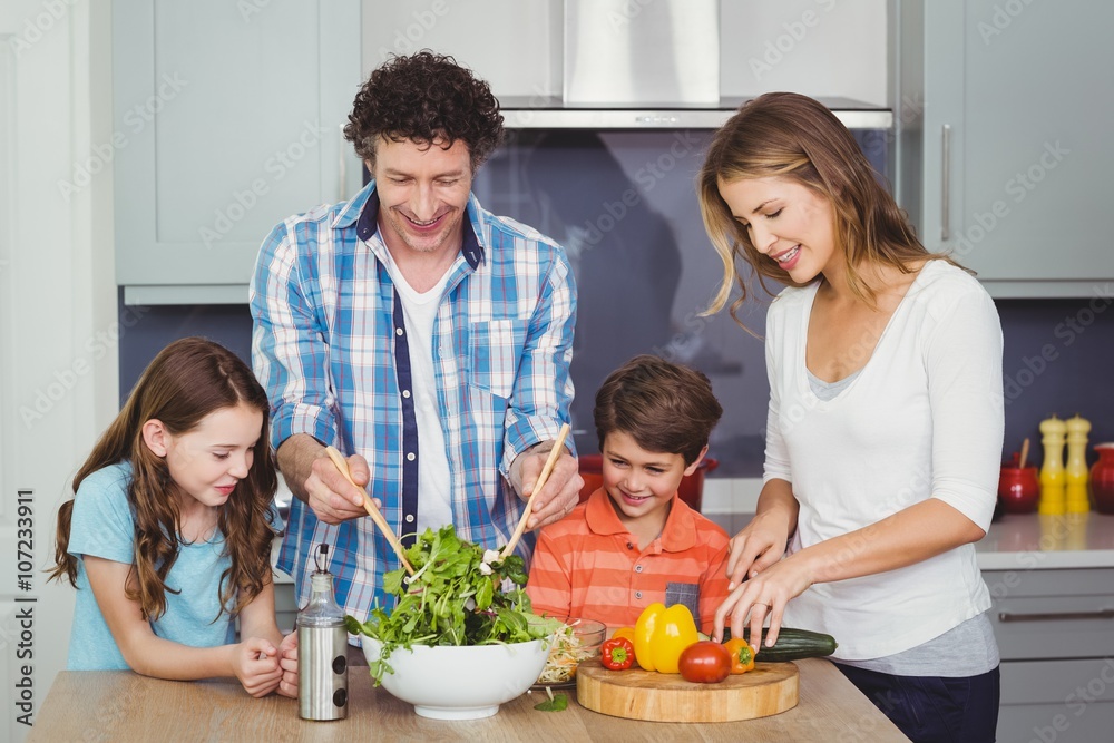 Parents and children preparing vegetable salad 
