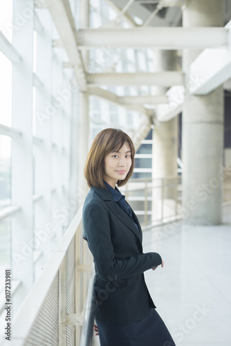 Attractive asian business woman smiling outside office